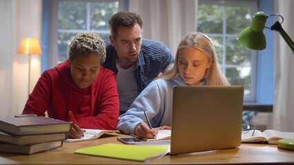 Diverse friends studying together in university common room preparing for exams