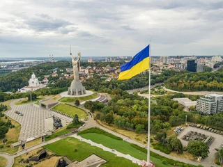 Poster Aerial drone view. Ukrainian flag on a high flagpole in Kiev. © Sergey