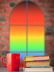 Fototapeta premium books and a red cup on the table, against the background of the window