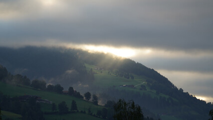 sunrise with dark clouds and sunlight over the mountains