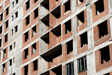 Detail of residential building under construction. Concrete structure with metal struts and temporary wooden railings. High-rise residential building under construction