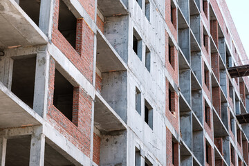 Detail of residential building under construction. Concrete structure with metal struts and temporary wooden railings. High-rise residential building under construction