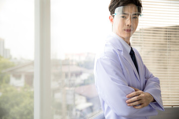 Fototapeta premium portrait of a confident male doctor standing by the window