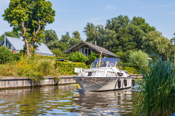 Fototapeta premium Motorboat entering Paterswoldsemeer a lake near Groningen in the Netherlands on a summer day