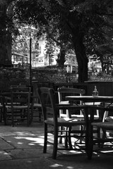 Fototapeta na wymiar table and chairs in a cafe (in the central square of a village) (black & white)