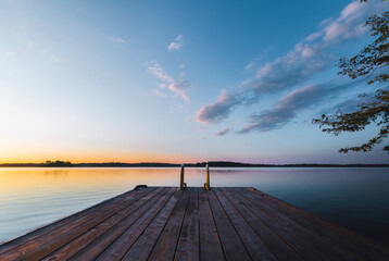 Dock on lake at sunset with calm waters