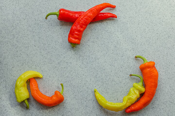 yellow, orange and red hot peppers on a gray table. Concept of the harvest season, bright autumn.