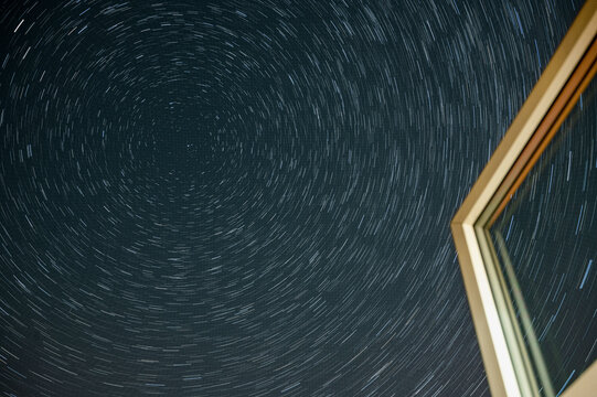 Northern Hemisphere Star Trails Through A Window And Following Polaris, The North Star And The Plough Constellation During The Covid-19 Pandemic With Little Airplane Activity Remains. 12 August 2020