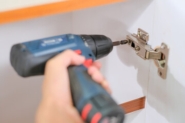 Installation of furniture hinges on the cabinet door.