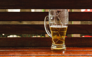 Glass with half a beer on the table.