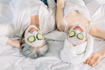 Close up top image of women, senior gray haired lady mother and her young pretty daughter having...