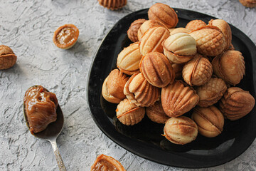nuts with condensed milk close-up with shift to the right on a gray background