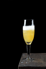 Cocktail with champagne in a champagne glass against the black background. Copy space