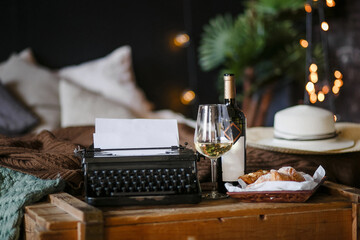 The inspiration of a writer typing texts on a vintage typewriter. Freelancer Breakfast croissants and wine. Office in the loft style