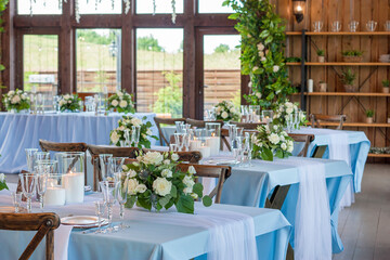 The restaurant is decorated with blue textiles and flowers on the wedding day