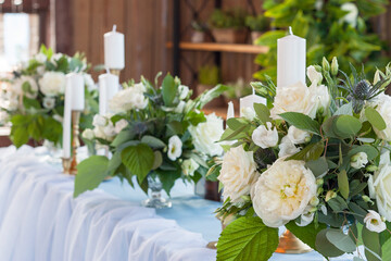 Flower arrangements with white flowers are on the table