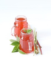 Drink, infusion of raspberry leaves and branches in a glass jar on a light background