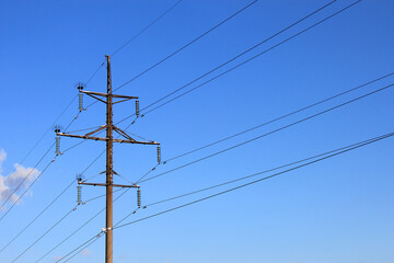 Power pole and power lines against the blue sky