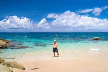 Fototapeta na wymiar Happy young man take selfie on action camera in snorkeling mask background beautiful azure sea lagoon