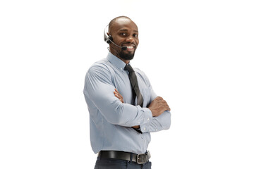 Talking and smiling, hands crossed. Young african-american call center consultant with headset on...