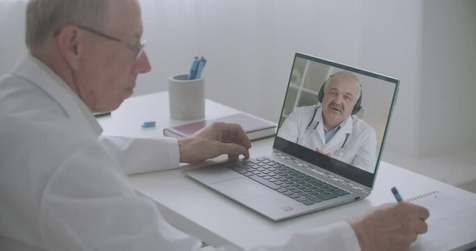 two virologists and infectiologist are discussing pandemic of coronavirus, chatting by web camera of notebooks
