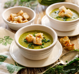  Creamy soup  of zucchini and herbs with garlic croutons close up view. Healthy vegetarian food