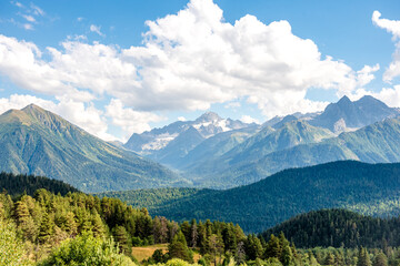Caucasus mountains in the country of Russia. Beautiful mountain landscape. Nature and mountain background. Mountain landscape and large white clouds over the mountains.