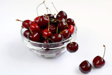 Ripe juicy sweet cherry lies in a glass bowl