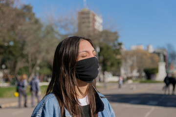 Fototapeta premium Mujer joven al sol con barbijo
