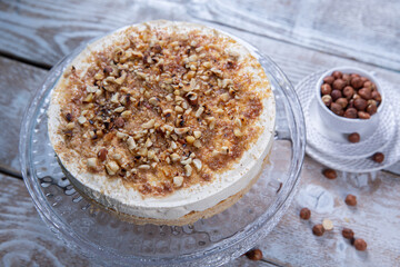 Cheese cake with hazelnuts on wood background