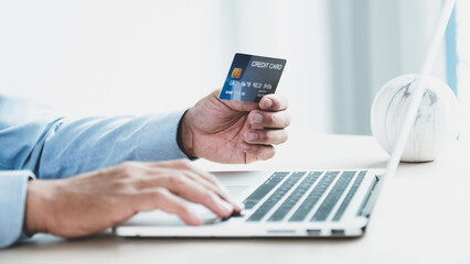 Businessman hand holding credit card to online shopping from home, payment e-commerce, internet banking, spending money for next holidays