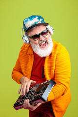 Party guy. Portrait of senior hipster man in fashionable eyewear isolated on green studio...
