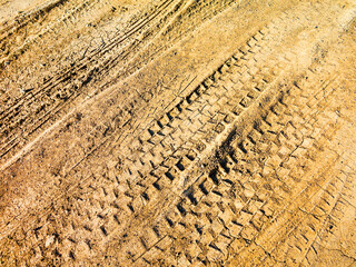 Traces of off-road tires. Cracked earth on country road with traces of tires, cars, cracks and dirt. To use as background.