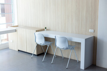 A work desk with white chairs in the sunny-glazed room provides light for work and relaxation.