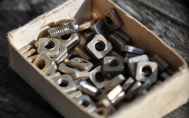 Closeup view nuts and screws in Matchbox Various metal details in cardboard box