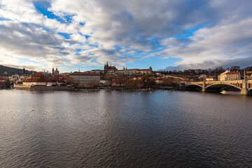 Fototapeta na wymiar Beautiful view of Mala Strana old district of Prague on the Vltava river side with Wallenstein Palace and Prague Castle, on sunny winter day with blue sky and cloud, Czech Republic