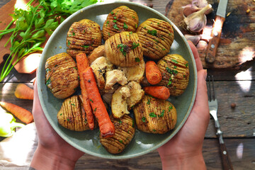 Baked potatoes with carrots and chicken breast. Gray plate. Wooden background. Delicious and...