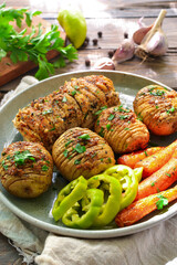 Baked potatoes with carrots and chicken breast. Gray plate. Wooden background. Delicious and healthy lunch. Hasselback potatoes. Vertical view