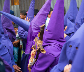 The procession of the cucuruchos in Quito during Easter with a man carrying a Jesus Christ statue...