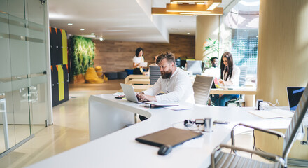 Confident businessman working on project and using laptop