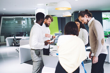 Obraz premium Multiethnic coworkers doing paperwork during meeting in workplace