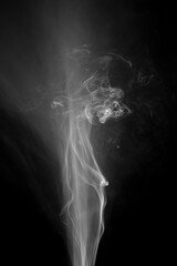 White smoke fragments on a black background.