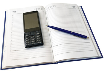 Notebook, pen and cellular telephone on a white