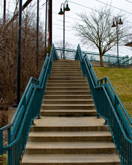 Obraz premium Concrete Steps Leading Up to a Train station With Blue Railings on Each Side