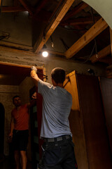 Two workers dismantled the old door and took the old wooden box outside to further install the new front door.