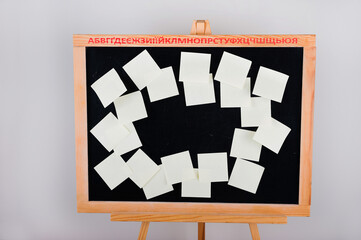 Stationery stickers close-up and copy space. Ukrainian alphabet on a chalkboard. Notes for remind....