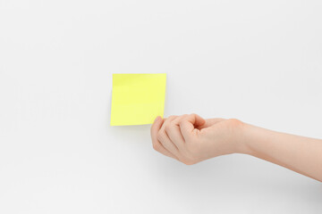 Yellow sticker or sticky post-it note in hand.