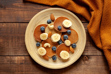 American pancakes with berry and bananas, top view