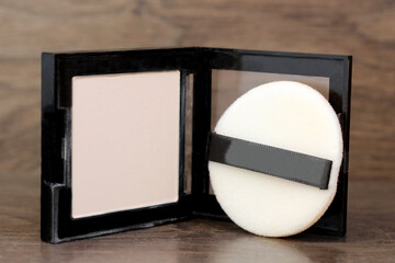 Beige face powder on a wooden background