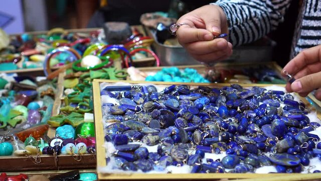 Tourists hands picking beautiful natural blue stone accessory of Egypt in Luxor night market